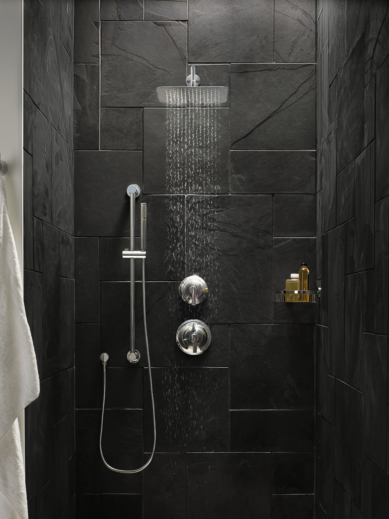 black tile shower with overheard water feature