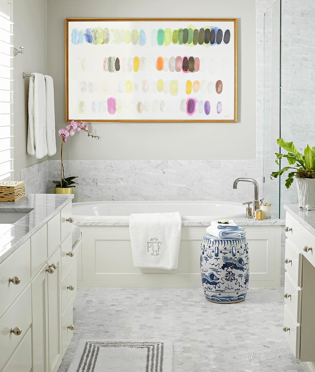 neutral bathroom with large statement art above tub